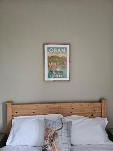 ein Bild über einem Bett, auf dem ein Hund sitzt in der Unterkunft Central Oban 2BR Short walk to Ferries and Harbour in Oban + 22 Fotos