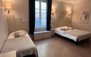 a bedroom with two beds and a window at Hotel du Pot d'Etain in Châlons-en-Champagne