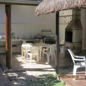 un grupo de sillas blancas y una mesa en la cocina en Pousada Brasil Tropical, en Ilha do Mel