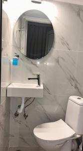 a bathroom with a toilet and a sink and a mirror at PerAmore Apartment in Nea Peramos +15 photos