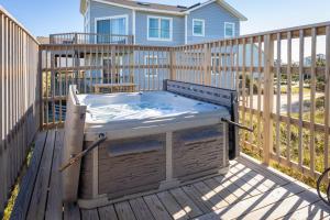 een hot tub op een terras voor een huis bij Oceanfront Views Private Beach Access and Hot Tub in Nags Head