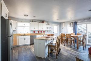 een keuken met witte kasten en een tafel en stoelen bij Oceanfront Views Private Beach Access and Hot Tub in Nags Head