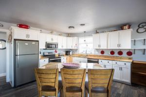 een keuken met witte kasten en een tafel met stoelen bij Oceanfront Views Private Beach Access and Hot Tub in Nags Head