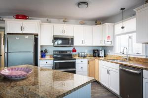 een keuken met witte kasten en een granieten aanrecht bij Oceanfront Views Private Beach Access and Hot Tub in Nags Head +41 foto's
