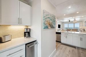 een keuken met witte kasten en een koelkast bij HP 24W Condo by 30A Escapes in Rosemary Beach +19 foto's