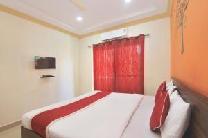 a bedroom with a bed with a red curtain at Hotel O Garden Green in Bengaluru
