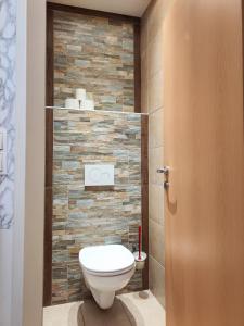 a bathroom with a toilet and a stone wall at The Small Nest in Vienna