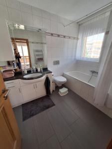 a bathroom with a sink and a tub and a toilet at Charmant appartement à Leukerbad - Lovely apartment in Leukerbad in Leukerbad +7 photos