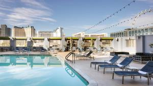 a pool on the rooftop of a hotel with lounge chairs at StripViewSuites at Platinum in Las Vegas