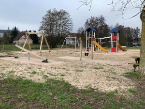 a playground with three swings and a slide at House MayFa in Riedseltz
