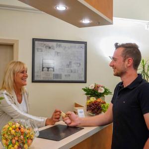 a woman standing next to a man at a counter at Fränkischer Hof Hotel Garni in Alzenau