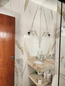 a bathroom with a sink and a marble wall at Casa Bahia Farm Show in Luis Eduardo Magalhaes +10 photos