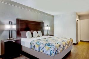 a hotel room with a bed and two lamps at Home Place Suites in Bartlesville +30 photos