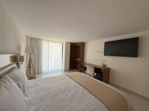 a hotel room with a bed and a flat screen tv at Hotel Casa Kavia Vallarta in Puerto Vallarta