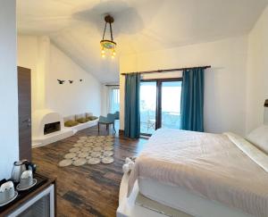 a bedroom with a bed and a room with a fireplace at Sazlı Shores in Ayvacık