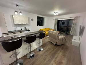 a kitchen and living room with a counter and chairs at Busteniview in Buşteni
