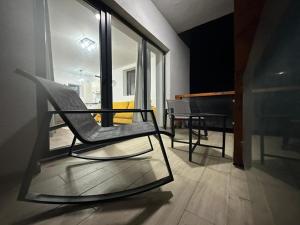 a black chair sitting in a room with a piano at Busteniview in Buşteni
