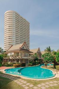 un grand immeuble d'appartements avec une grande piscine dans l'établissement บ้านทะเลสำราญ by May, à Cha Am