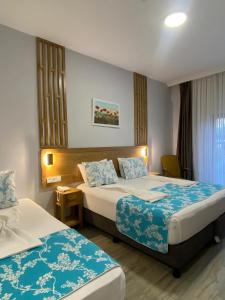 ein Hotelzimmer mit zwei Betten mit blau-weißer Bettwäsche in der Unterkunft Hotel Panaya in Gokceada Town