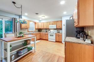 a kitchen with wooden cabinets and a white refrigerator at Less Than 1 Mi to Main St Rural Gem in Cherry Valley in Cherry Valley +18 photos