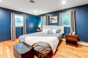 a blue bedroom with a bed and two windows at Less Than 1 Mi to Main St Rural Gem in Cherry Valley in Cherry Valley