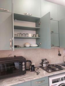 a kitchen counter with a microwave and a stove at Batumi in Itʼkhvisi +12 photos