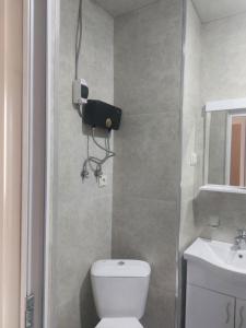 a bathroom with a toilet and a camera on the wall at Batumi in Itʼkhvisi