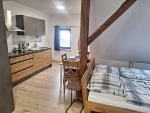 a bedroom with a bed and a table and a kitchen at Ferienwohnung am Backhaus 5 in Weimar