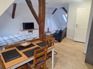 a dining room and living room with a table and chairs at Ferienwohnung am Backhaus 5 in Weimar