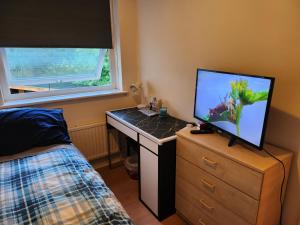 a bedroom with a desk with a television on it at UnknownRooms in London