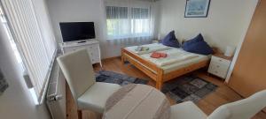 una piccola stanza con un letto e una televisione di Ferienhaus - Wohnung- Havelblick a Phöben