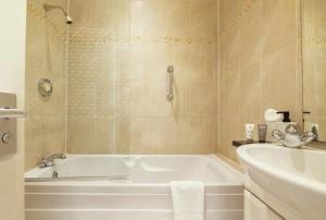a bathroom with a tub and a sink at Stoke Lodge Hotel in Stoke Fleming