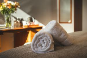 a rolled up towel sitting on top of a bed at Stoke Lodge Hotel in Stoke Fleming