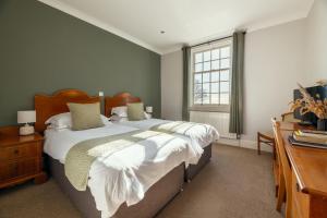 a bedroom with a large bed and a window at Stoke Lodge Hotel in Stoke Fleming
