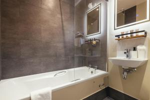 a bathroom with a bath tub and a sink at Stoke Lodge Hotel in Stoke Fleming +26 photos