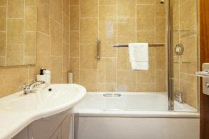 a bathroom with a sink and a tub and a shower at Stoke Lodge Hotel in Stoke Fleming