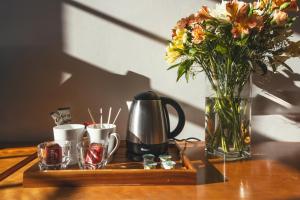 a tray with a vase of flowers and cups on a table at Stoke Lodge Hotel in Stoke Fleming