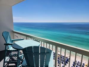 a balcony with a table and chairs and the ocean at Pelican Beach Resort Top 20th Floor Condos with Ocean View in Destin