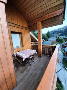 莱斯奥琉斯Résidence Lachat - Bel appartement 2 pièces 4 personnes proche de Méribel centre MAE-1785的木制门廊,甲板上配有桌子 更多6张照片