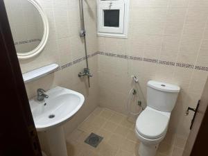 a bathroom with a white toilet and a sink at Pyramiza Fahaheel بيراميزا الفحيحيل in Kuwait