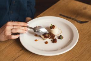 a person eating a plate of food with a spoon at Stoke Lodge Hotel in Stoke Fleming