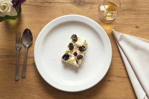 a white plate with a piece of cake on a table at Stoke Lodge Hotel in Stoke Fleming