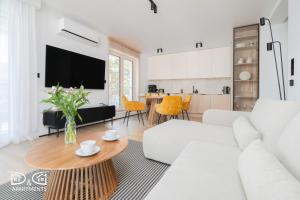 een woonkamer met een witte bank en een tafel bij Zielona 16 D&D Apartments in Międzywodzie