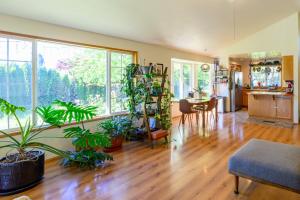 a living room with potted plants and a kitchen at River House - 4 bedroom, 2 bath private home in Eugene