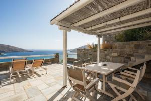 a patio with a table and chairs and the ocean at Seaside Bliss 3, Ganema Serifos in Ganema