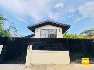 a house with a black fence and a gate at Upper East Inn- Bacolod in Bacolod
