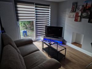 a living room with a couch and a flat screen tv at Glenleven share house in Bristol