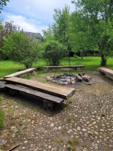 two picnic tables and a campfire in a park at Pokoje Gościnne Wojtek-2 in Białowieża