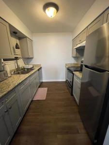 a kitchen with white cabinets and a stainless steel refrigerator at Cozy 2BR 2BA apt close to Siegen & Womans in Baton Rouge