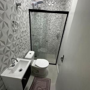 a bathroom with a shower and a toilet and a sink at Loft Lux SM 07 (Smart TV, Ar condicionado, Cozinha) in Chapecó